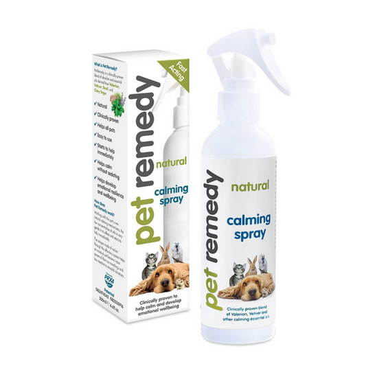 A bottle and box of pet calming spray on a plain white background. The product is labeled 'pet remedy natural calming spray' with images of a dog, cat, and puppy on the packaging.