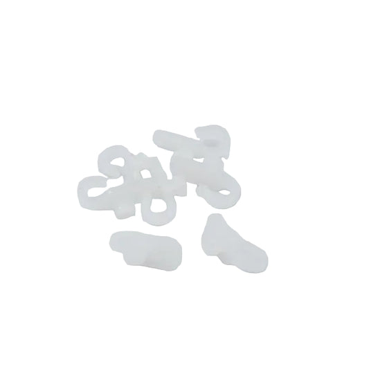 A small pile of translucent white plastic fastening or fastener pieces on a plain white background.