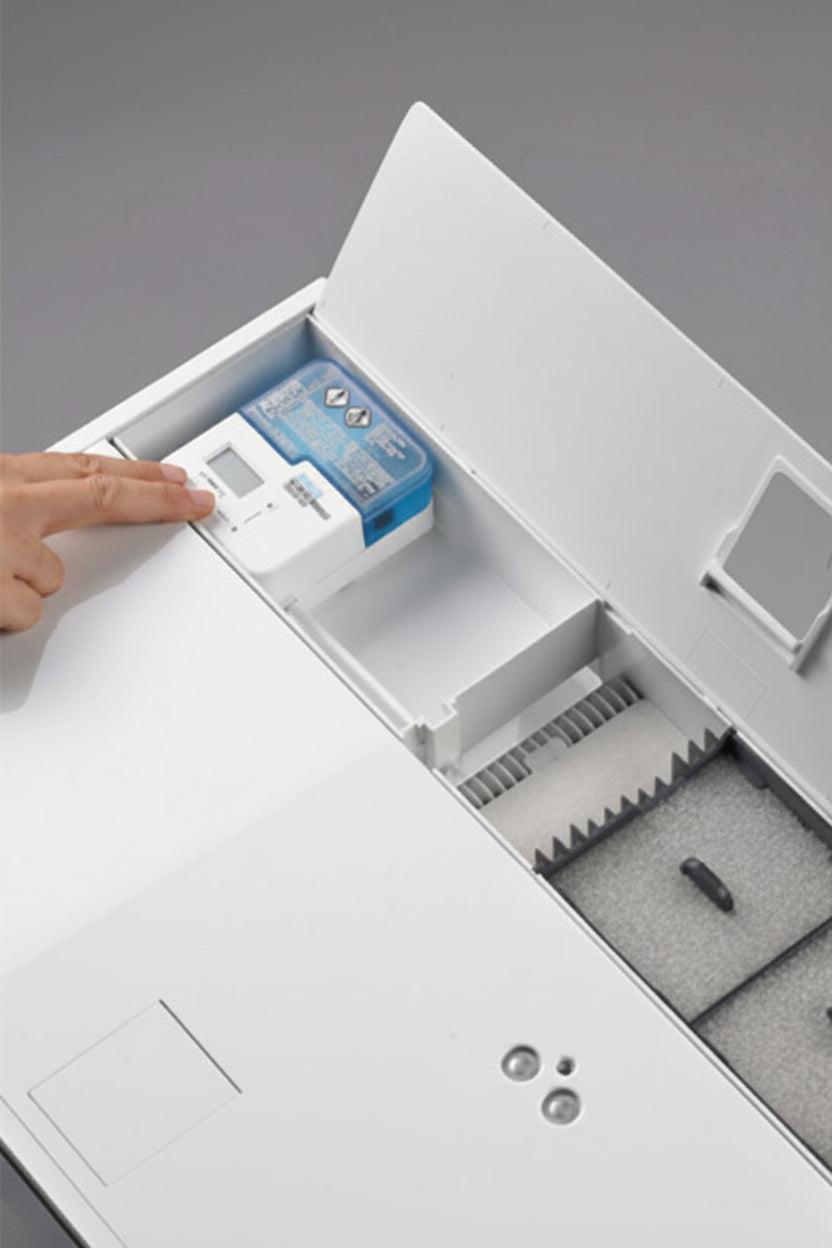 A close-up of an aquarium with its lid open, showing a small blue-and-white electronic device in a compartment and a gray foam-lined interior.