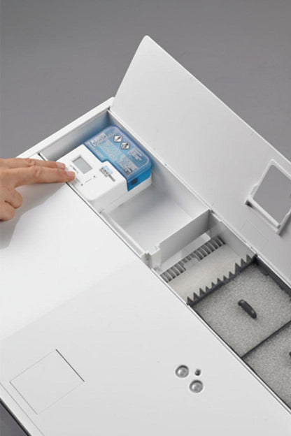 A close-up of an aquarium with its lid open, showing a small blue-and-white electronic device in a compartment and a gray foam-lined interior.