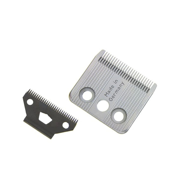Two metal clipper blades, one silver and one black, shown on a plain white background. The silver blade has 'Made in Germany' printed on it.