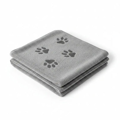 A folded gray microfiber dog grooming towel with three dark gray paw prints, shown on a plain white background.