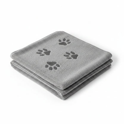A folded gray microfiber dog grooming towel with three dark gray paw prints, shown on a plain white background.