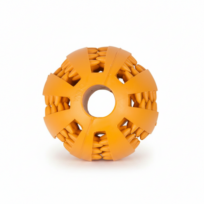 An orange textured rubber dog toy ball with a central hole and radial textured segments, shown on a plain white background.