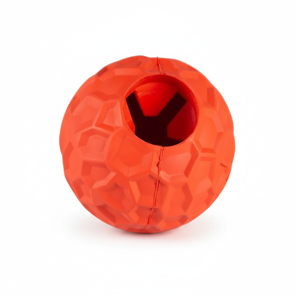 An orange-red textured rubber ball dog toy with a central hole for treats, shown on a plain white background.