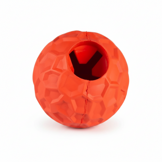 An orange-red textured rubber ball dog toy with a central hole for treats, shown on a plain white background.